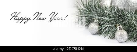 Banner di Natale e Capodanno con ramo in abete verde e palline bianche su sfondo bianco. Composizione natalizia con spazio per la copia. Foto Stock