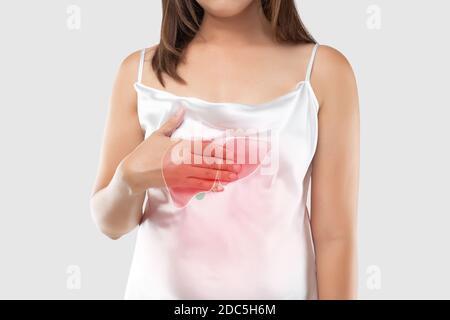 La foto del fegato sul corpo della donna contro sfondo grigio, epatite, concetto con la sanità e la medicina. Foto Stock