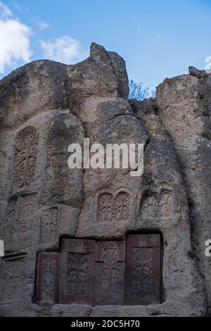 Khachkars, stele memoriali con croci armene scolpite sulla scogliera nel complesso del monastero medievale di Geghard fondato nel IV secolo da Gregorio l'Illuminatore nella provincia di Kotayk in Armenia Foto Stock