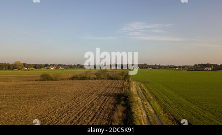 L'alba o il tramonto, drammatici e colorati, si innalzano su un campo erboso di campagna, girato da un drone in alto. Foto di alta qualità Foto Stock