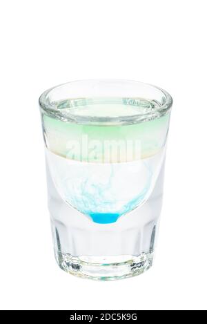 Gli shot di alcol si cocktail in un bicchiere isolato su sfondo bianco. Strato composto da liquore verde, bianco e blu Foto Stock