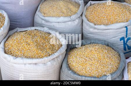 Grandi borse bianche con mais su un mercato in Kirghizistan. Foto Stock