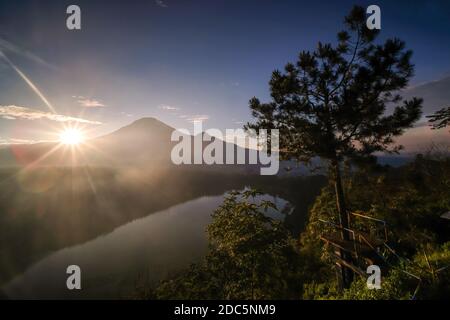 La bellezza del lago Menjer sullo sfondo del Monte Sindoro. Destinazione turistica di Wonosobo, Giava Centrale. Silhouette di scenario contro un backgro Foto Stock