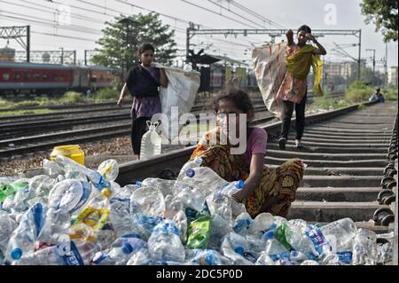 Una donna appartenente alla casta degli intoccabili (Dalit) seleziona bottiglie e altri contenitori di plastica raccolti nelle strade di Kolkata per la vendita. Foto Stock