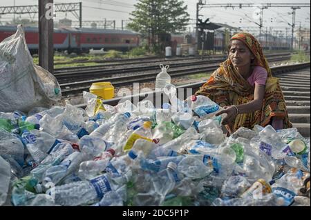 Una donna appartenente alla casta degli intoccabili (Dalit) seleziona bottiglie e altri contenitori di plastica raccolti nelle strade di Kolkata per la vendita. Foto Stock