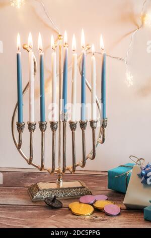 La festa di Hanukkah Menorah con candele su un tavolo di legno Foto Stock