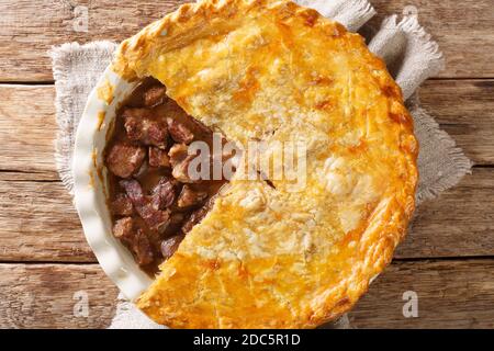 la torta di bistecca è una tradizionale torta di carne servita in Gran Bretagna ed è composta da bistecca alla rosticceria e sugo di manzo, racchiusa in un guardaroba di pasticceria nel piatto sulla ta Foto Stock