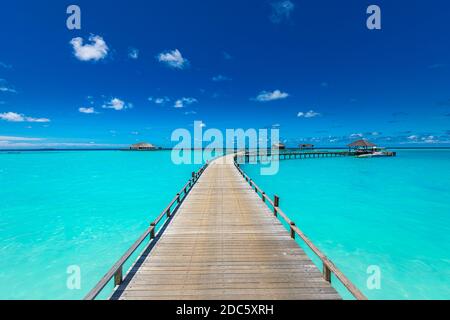 Panorama di ville d'acqua bungalow sulla spiaggia tropicale nelle Maldive durante il giorno d'estate. Paesaggio estivo di lusso, mare. Sfumature di blu in tropico Foto Stock