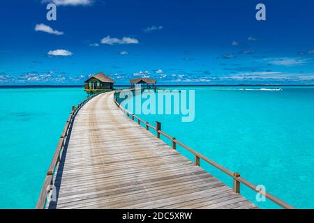 Panorama di ville d'acqua bungalow sulla spiaggia tropicale nelle Maldive durante il giorno d'estate. Paesaggio estivo di lusso, mare. Sfumature di blu in tropico Foto Stock