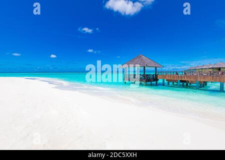 Panorama di ville d'acqua bungalow sulla spiaggia tropicale nelle Maldive durante il giorno d'estate. Paesaggio estivo di lusso, mare. Sfumature di blu in tropico Foto Stock