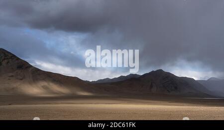 Montagne vicino Karakul con vista su alte montagne nere, deserto e valle in Tagikistan. Foto Stock