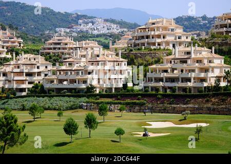 Vista sul campo da golf El Higueral verso i blocchi di appartamenti sulla collina, Benahavis, Spagna. Foto Stock