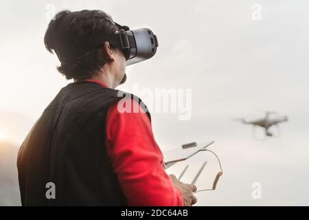 Pilota professionista maschile che fa esperienza fpv utilizzando gli occhiali di realtà virtuale E drone - concetto di tecnologia e innovazione Foto Stock