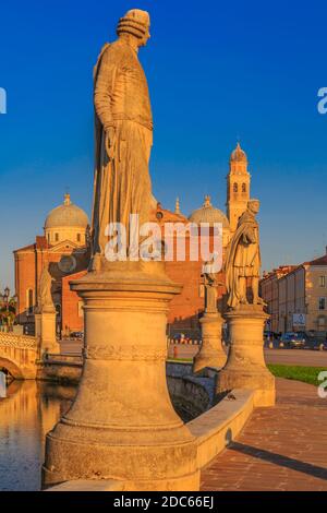 Vista delle statue di Prato della Valle durante l'ora d'oro e della Basilica di Santa Giustina visibile sullo sfondo, Padova, Veneto, Italia Foto Stock