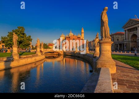 Vista delle statue di Prato della Valle durante l'ora d'oro e della Basilica di Santa Giustina visibile sullo sfondo, Padova, Veneto, Italia Foto Stock