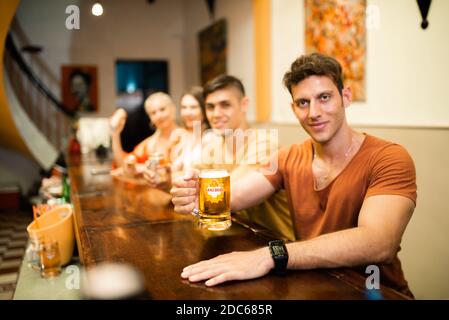 Gli uomini d'affari bevono birra Ganzberg, parlano e ridono mentre si riposano al pub Foto Stock