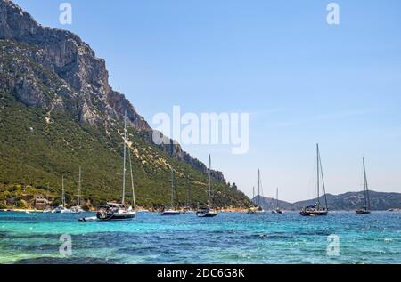 Tavolara, Sardegna / Italia - 2019/07/18: Barche e barche nella pittoresca Tirrenica porti del Mare al largo dell'isola di Isola Tavolara al largo della costa settentrionale di S. Foto Stock