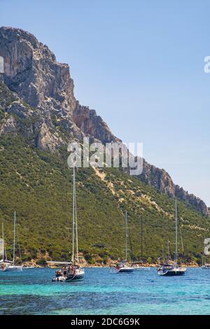 Tavolara, Sardegna / Italia - 2019/07/18: Barche e barche nella pittoresca Tirrenica porti del Mare al largo dell'isola di Isola Tavolara al largo della costa settentrionale di S. Foto Stock