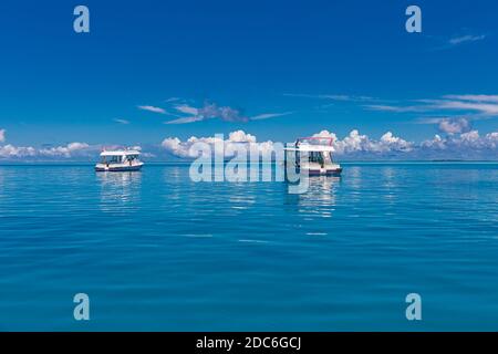 Yacht di lusso a vela sull'oceano alle Maldive, isola tropicale sullo sfondo. Concetto di vacanza di viaggio e viaggio in barca Foto Stock