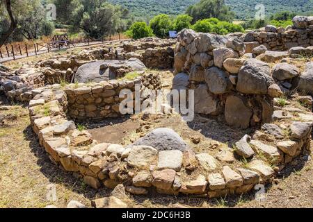 Arzachena, Sardegna / Italia - 2019/07/19: Rovine archeologiche del complesso nuragico la Prisgiona - Nuraghe la Prisgiona - con resti di pietra arrotondata Foto Stock