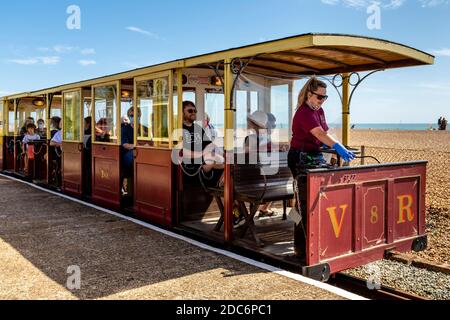 Un treno ferroviario elettrico Volk con passeggeri, Brighton Seafront, Brighton, East Sussex, Regno Unito. Foto Stock
