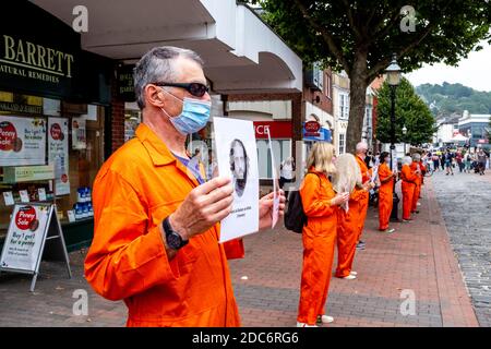 I membri del Lewes Amnesty International Group che indossano Orange Jump si addice alla protesta contro il campo di detenzione militare di Guantanamo, Lewes, Sussex, Regno Unito. Foto Stock