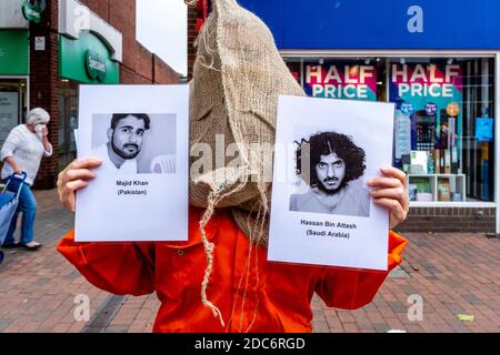 I membri del Lewes Amnesty International Group che indossano Orange Jump si addice alla protesta contro il campo di detenzione militare di Guantanamo, Lewes, Sussex, Regno Unito. Foto Stock