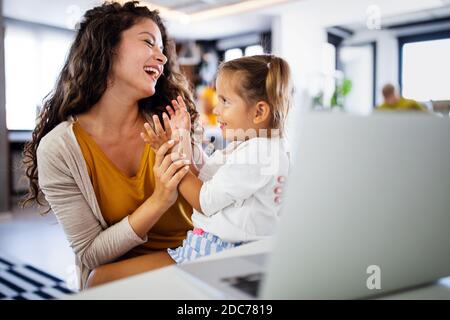 Giovane madre con bambino che lavora da casa Foto Stock