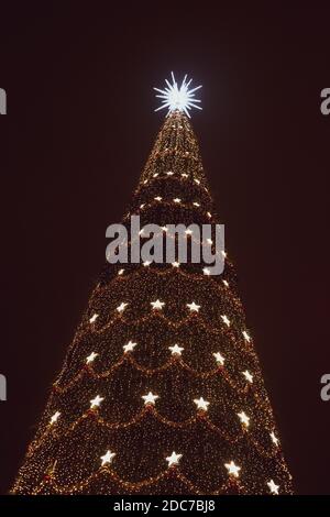 Enorme albero di Natale pieno di luci in una fiera di Natale Foto Stock