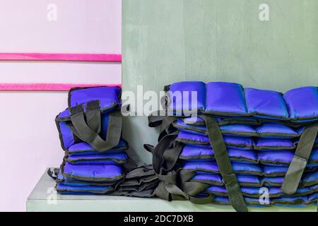 set di pesi sportivi blu sul polso si trovano dentro una pila nella sala fitness Foto Stock