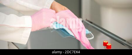 Donna dottore che indossa guanti protettivi in gomma sulle mani il laboratorio Foto Stock
