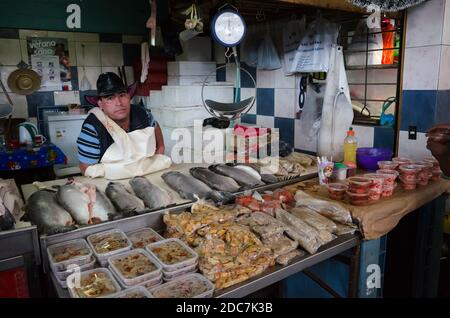 Osorno, Cile - Febbraio, 2020: Vendita Stallone mercato del pesce con diversi pesci di mare cozze con vecchie scale sul mercato locale del pesce. Addetto alle vendite Foto Stock