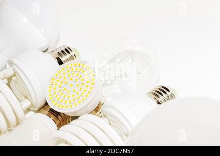 Diverse lampadine a LED e lampade fluorescenti compatte con Dimensione della base a vite maschio E27 su una lampada sfondo Foto Stock