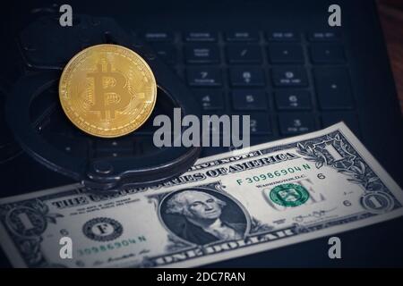 Manette e bitcoins della polizia. Il concetto di problemi con la legge nell'estrazione illegale di criptovalute e le transazioni con bitcoins. Foto Stock