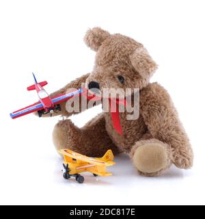 Piccolo peluche carino che gioca con aerei giocattolo Foto Stock