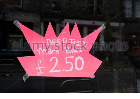 Deep Fried Mars Bar segno delicatezza per la vendita in un Scottish Fish and chip Shop Foto Stock