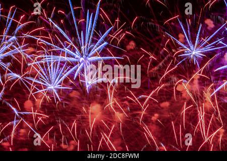 Splendidi fuochi d'artificio multicolore esplodono in cielo illuminato. Festoso sfondo luminoso Foto Stock