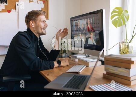 Lavoro da casa. Giovane che dispone di una videochiamata Zoom tramite un computer in ufficio. Soggiorno a casa e lavoro da casa Concept durante Covid-19 Foto Stock