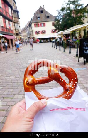 Gastronomia alsaziana, il bretzel, nelle strade di Kaysersberg, Alsacia, Francia Foto Stock