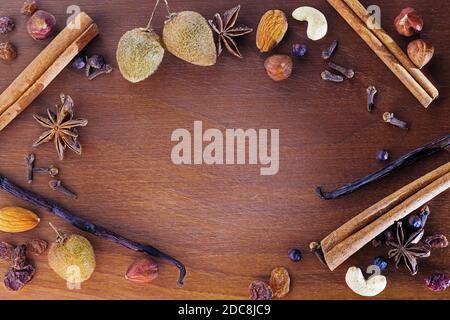 Spezie aromatiche natalizie e frutta su tavola di legno di noce. Cibo, spezie e concetti natalizi Foto Stock