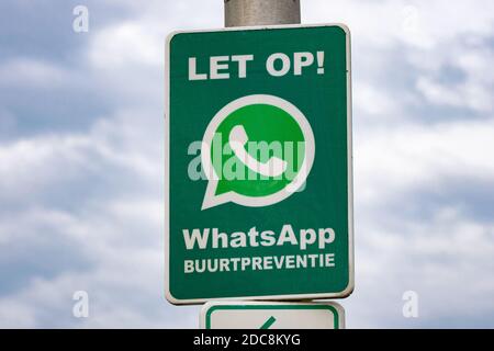 Indica che un orologio di quartiere è attivo tramite l'app di chat Whatsapp. (Olandese: Buurtpreventie). Guarda il cartello per scappare ladri e criminali. Foto Stock