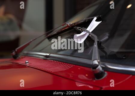 Segnalazione di un biglietto di violazione del parcheggio dietro un tergicristallo anteriore su un'auto classica Foto Stock