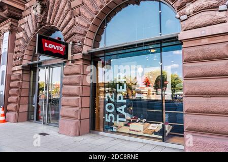 Amburgo, Germania - 25 agosto 2019: Facciata di un negozio di abbigliamento Levis e di un negozio di farmacia a Jungfernstieg, via dello shopping a Neustadt, Amburgo, in tedesco Foto Stock