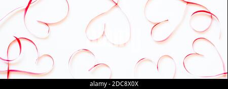 Cuori rossi fatti di nastro su banner di sfondo bianco. Foto Stock