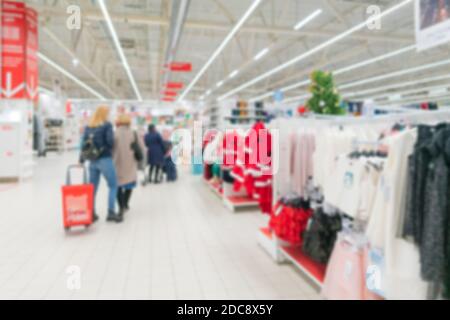 Supermercato sfocato. Vendita di merci in un negozio al dettaglio. Sfondo offuscato dei consumatori in maschere mediche in un negozio. Foto Stock