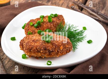 Due succulenti cotolette di carne da vicino su uno sfondo naturale di legno. Foto Stock