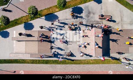 Vista aerea di giovani felici con strumenti musicali in un parco skate sul terrapieno. Trama surreale. Foto Stock