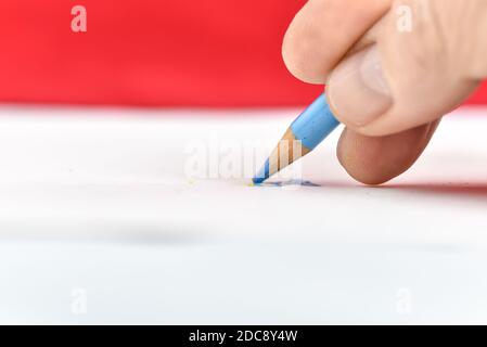 vista ravvicinata della matita da disegno colorata su carta bianca e sfondo rosso Foto Stock