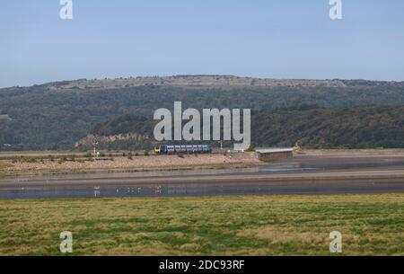 Treno Northern Rail CAF class195 che attraversa il viadotto di Arnside attraverso l'estuario del fiume Kent sulla panoramica linea ferroviaria della costa della Cumbria Foto Stock