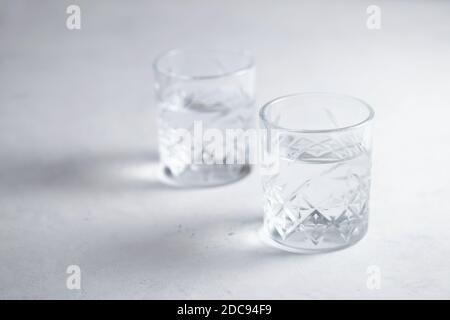 Due bicchieri d'acqua o di liquido trasparente sul tavolo stile di vita sano Foto Stock